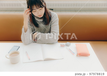 カフェで勉強をする若い女子大生の写真 97978819