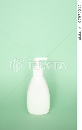 White plastic soap dispenser pump bottle on pastel green background. Skin care lotion, shampoo bottle, bath and body lotion. Bathroom Accessories. 97979019