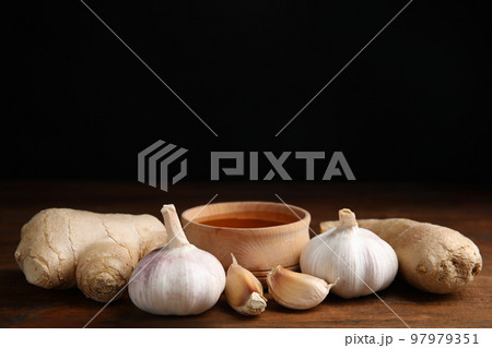 Fresh garlic and other natural cold remedies on wooden table. Space for text 97979351