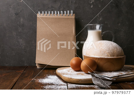 Composition with raw eggs and blank notebook on wooden table. Baking pie Composition with raw eggs and blank notebook on wooden table. Baking pie 97979377