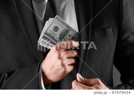 Man with bribe money on dark background, closeup 97979434