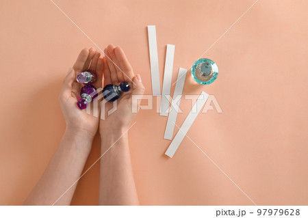 Woman with perfume bottles on peach background, top view 97979628