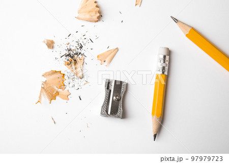 Graphite pencils, shavings and sharpener on white background, top view 97979723