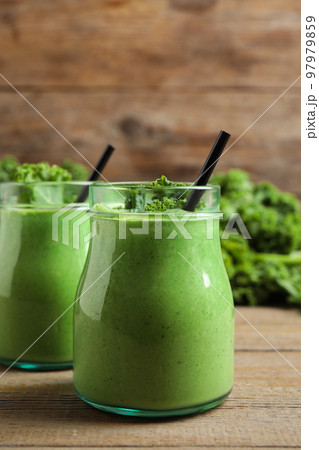 Tasty fresh kale smoothie on wooden table Tasty fresh kale smoothie on wooden table 97979859