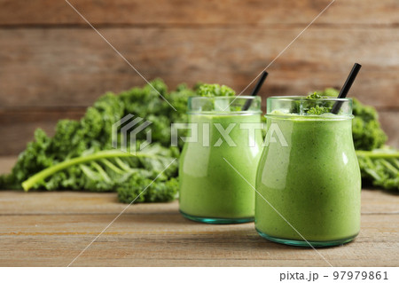 Tasty fresh kale smoothie on wooden table Tasty fresh kale smoothie on wooden table 97979861