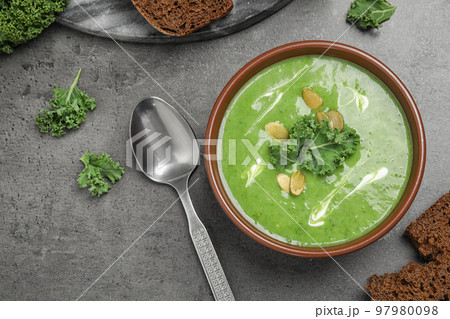 Tasty kale soup served on grey table, flat lay 97980098