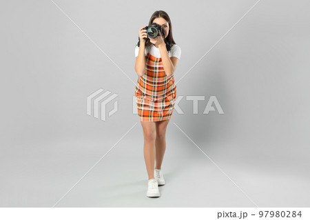 Professional photographer working on light grey background in studio Professional photographer working on light grey background in studio 97980284