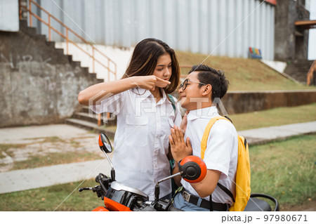 A girl student points finger at a male student A girl student points finger at a male student 97980671
