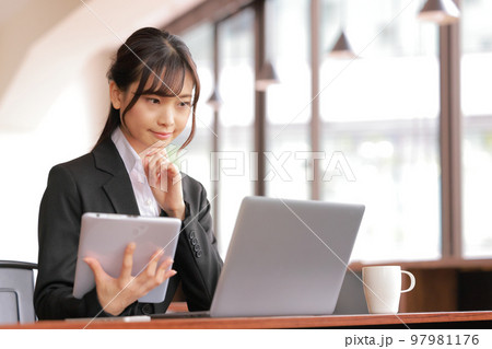 デスクワーク_タブレットを持ち考える女性1 97981176