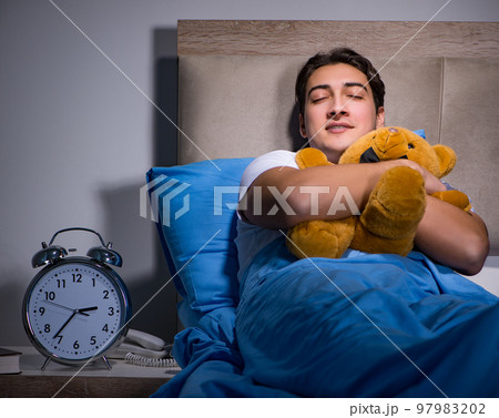 Young man sleeping in the bed Young man sleeping in the bed 97983202