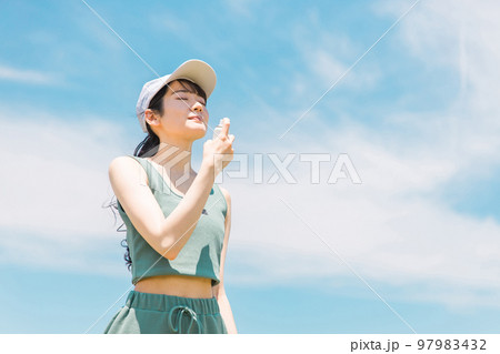 夏の運動前に制汗スプレー・UVケア・デオドラントケアをする日本人女性 97983432