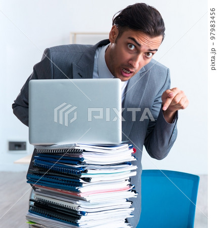 Businessman with heavy paperwork workload 97983456
