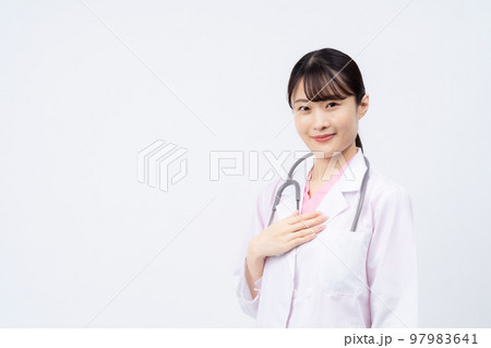 手を胸に当てる若い女性の医者 手を胸に当てる若い女性の医者 97983641