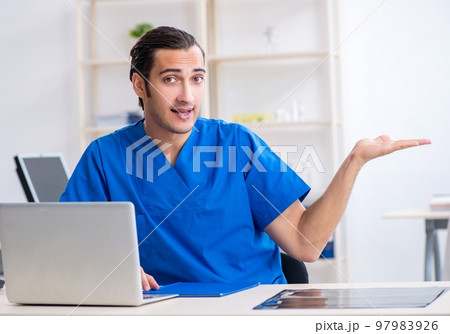 Young male doctor working in the clinic Young male doctor working in the clinic 97983926