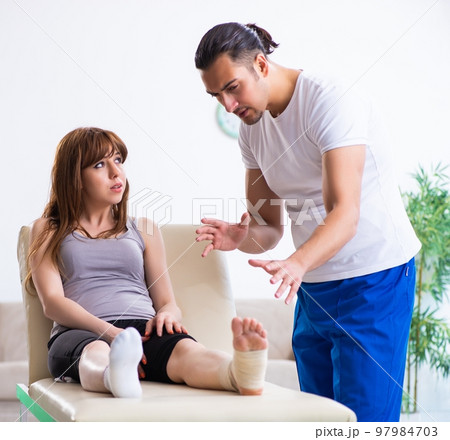 Leg injured woman visiting young doctor traumatologist 97984703