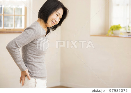 シニア腰痛イメージ　腰を押さえるシニア、ミドル女性 97985072