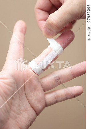 指にテーピングを巻く男性 指にテーピングを巻く男性 97985098