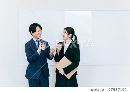 コーヒーを飲んで休憩するスーツ姿のビジネスマン・ビジネスウーマン(笑顔・男女) コーヒーを飲んで休憩するスーツ姿のビジネスマン・ビジネスウーマン(笑顔・男女) 97987195