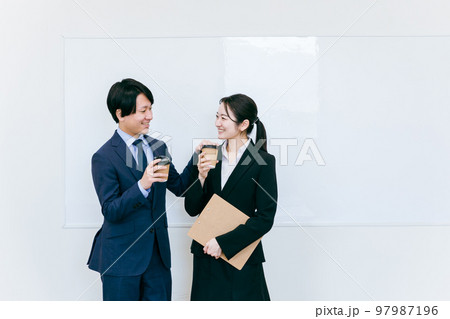 コーヒーを飲んで休憩するスーツ姿のビジネスマン・ビジネスウーマン（笑顔・男女） 97987196