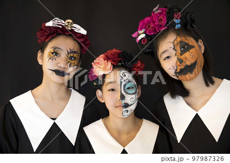 フェイスペイントをした小学生女の子たち ハロウィンメイクの写真素材