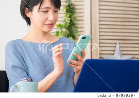 車椅子に座りながらスマートフォンを操作する若い女性 多様性社会イメージ 車椅子に座りながらスマートフォンを操作する若い女性 多様性社会イメージ 97989297