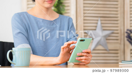 車椅子に座りながらスマートフォンを操作する若い女性 多様性社会イメージ 車椅子に座りながらスマートフォンを操作する若い女性 多様性社会イメージ 97989300