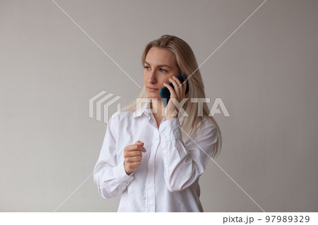 A young woman in a white shirt talking on the phone. A young woman in a white shirt talking on the phone. 97989329