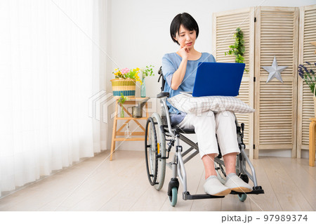 車椅子でノートパソコンを使う若い女性 多様性社会イメージ 車椅子でノートパソコンを使う若い女性 多様性社会イメージ 97989374