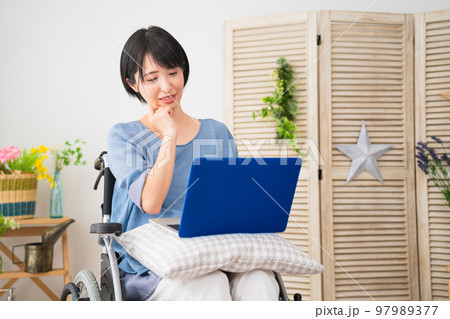 車椅子でノートパソコンを使う若い女性 多様性社会イメージ 車椅子でノートパソコンを使う若い女性 多様性社会イメージ 97989377