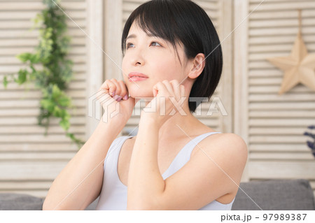 あごのセルフマッサージをする若い女性　美容イメージ 97989387