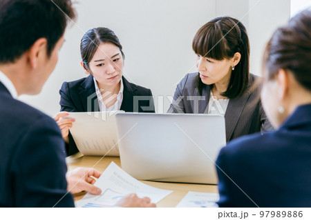 オフィスで困って先輩・上司に相談する後輩・部下のビジネスウーマン オフィスで困って先輩・上司に相談する後輩・部下のビジネスウーマン 97989886