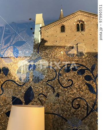 イタリア・ミラノ市内、お店のモザイクデコレーションと映り込んだ古い建築物が巧く融合した画像。 イタリア・ミラノ市内、お店のモザイクデコレーションと映り込んだ古い建築物が巧く融合した画像。 97990551