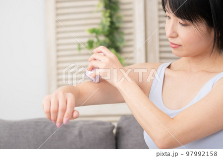 腕のセルフ脱毛をする若い女性　美容イメージ 97992158
