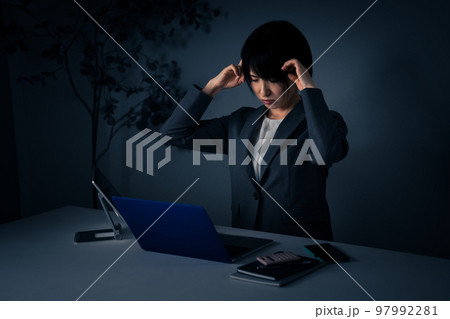 オフィスで頭をかかえる若いビジネスウーマン　残業イメージ 97992281