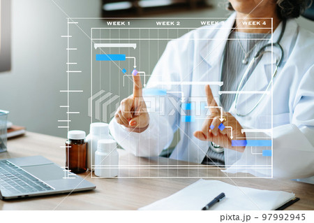 Project manager working and update tasks with Gantt chart scheduling diagram at hospital .success smart medical doctor working with smart medical doctor . 97992945