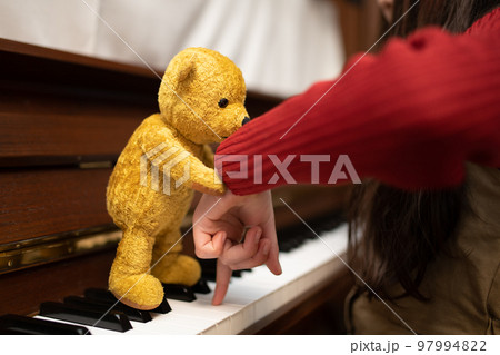 子供にピアノを教える熊の縫いぐるみ 子供にピアノを教える熊の縫いぐるみ 97994822