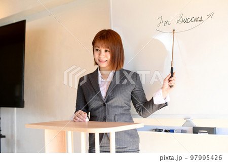 プレゼンするスーツを着た女性セミナー講師 97995426
