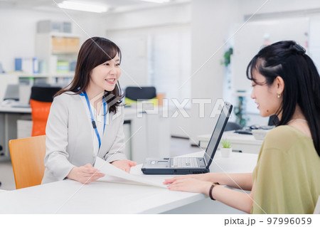 窓口で対応をする女性 窓口で対応をする女性 97996059