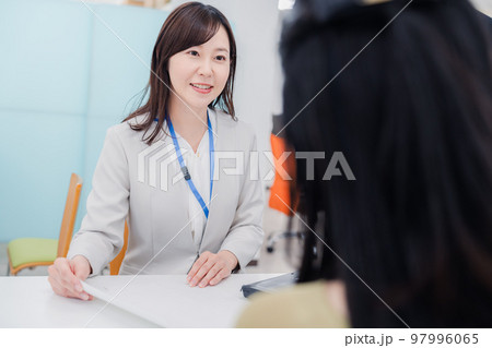 窓口で対応をする女性 窓口で対応をする女性 97996065