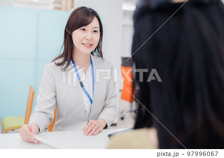 窓口で対応をする女性 97996067