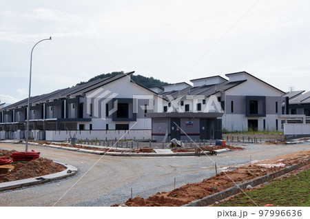 SELANGOR, MALAYSIA - JUNE 20, 2022: New double-story terrace house under construction in Malaysia. Have a wide porch. Utility facilities have also been built for future residents. SELANGOR, MALAYSIA - JUNE 20, 2022: New double-story terrace house under construction in Malaysia. Have a wide porch. Utility facilities have also been built for future residents. 97996636