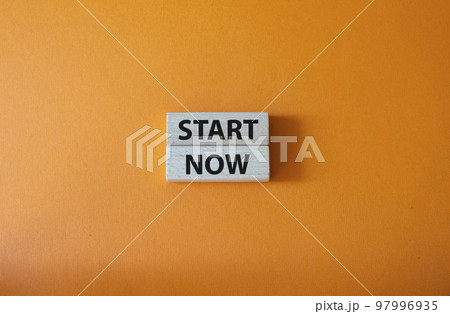 Start now symbol. Wooden blocks with words Start now. Beautiful orange background. Business and Start now concept. Copy space. 97996935