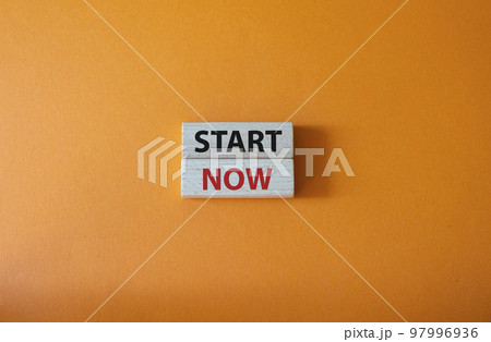 Start now symbol. Wooden blocks with words Start now. Beautiful orange background. Business and Start now concept. Copy space. 97996936