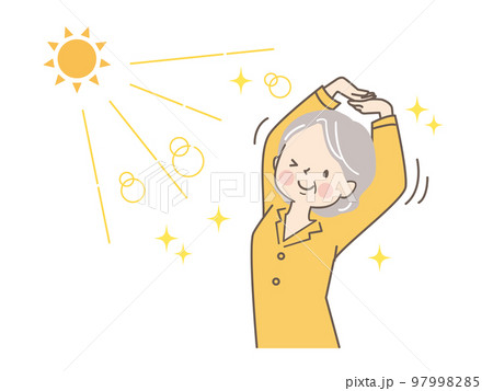 太陽の光を浴びながら伸びをするシニア女性 97998285