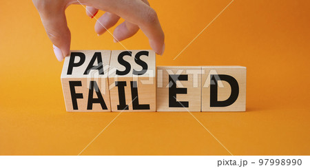 Passed and Failed symbol. Businessman hand turnes wooden cubes and changes word Failed to Passed. Beautiful orange background. Business and Passed and Failed concept. Copy space 97998990
