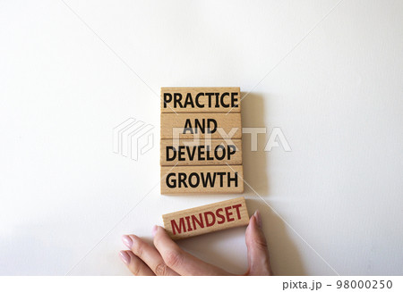 Practice and Develop growth mindset symbol. Wooden blocks with words Practice and Develop growth mindset. Businessman hand. Beautiful white background. Business concept. Copy space Practice and Develop growth mindset symbol. Wooden blocks with words Practice and Develop growth mindset. Businessman hand. Beautiful white background. Business concept. Copy space 98000250