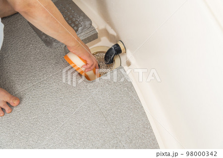 【浴室の排水口を掃除をするミドル主婦】 98000342