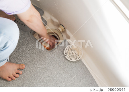 【浴室の排水口を掃除をするミドル主婦】 98000345