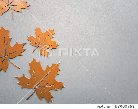 Metal orange maple leaf cut on concrete background with copy space for advertisement. Autumn, thanksgiving day and winter concept. 98000568