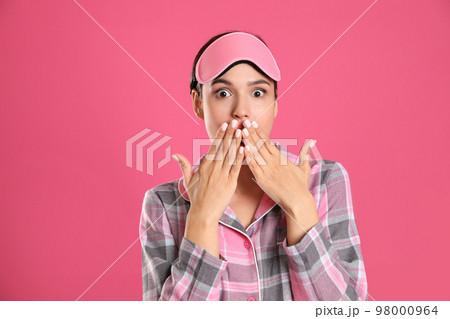 Beautiful woman wearing sleeping mask on pink background. Bedtime Beautiful woman wearing sleeping mask on pink background. Bedtime 98000964